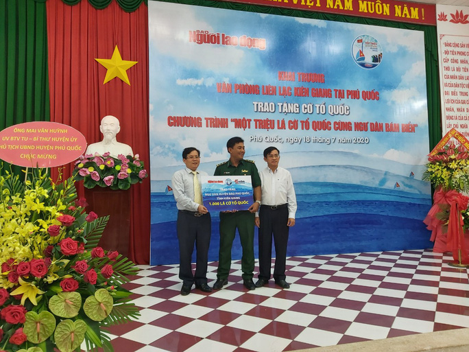 Tổng Biên tập Báo Người Lao Động và đại diện Tổng Công ty Điện lực Miền Nam trao bảng tượng tưng 1.000 lá cờ Tổ quốc cho Ban Chỉ huy Biên phòng cửa khẩu cảng Dương Đông