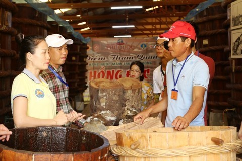 Khách du lịch tham quan và mua sản phẩm tại một cơ sở sản xuất nước mắm Phú Quốc
